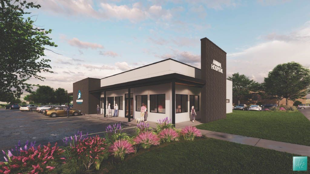 Modern building with black and white facade, sidewalk, landscaping, and cars parked in front.