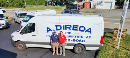 White A. Direda plumbing van parked outdoors with two workers standing in front