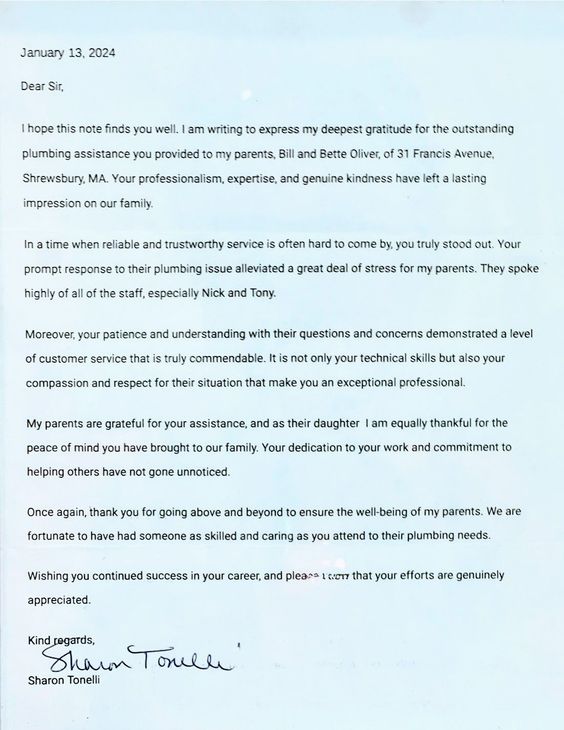 Blurry photographed typed letter on white paper with a handwritten signature at the bottom.