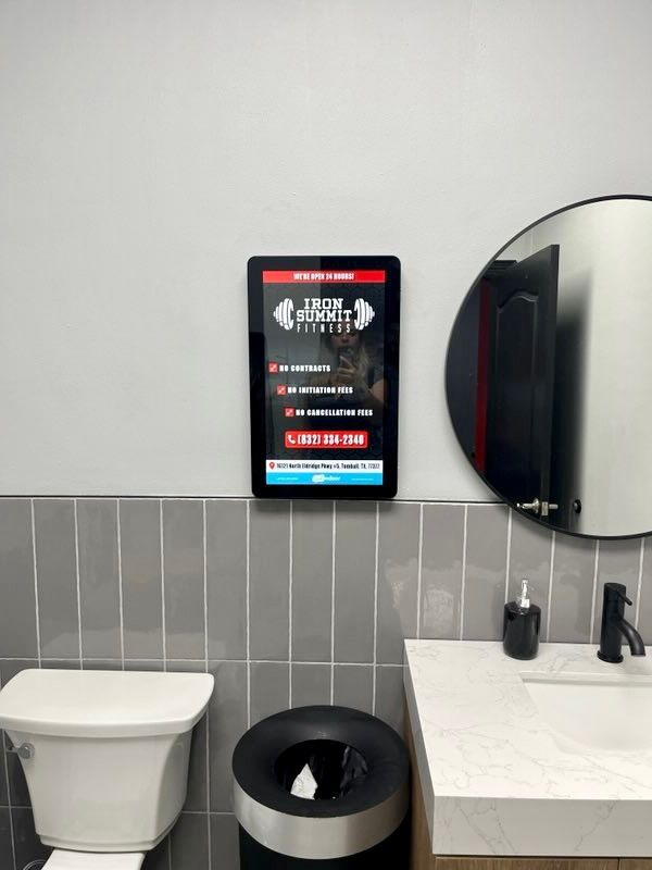 A bathroom with a toilet , sink and mirror.