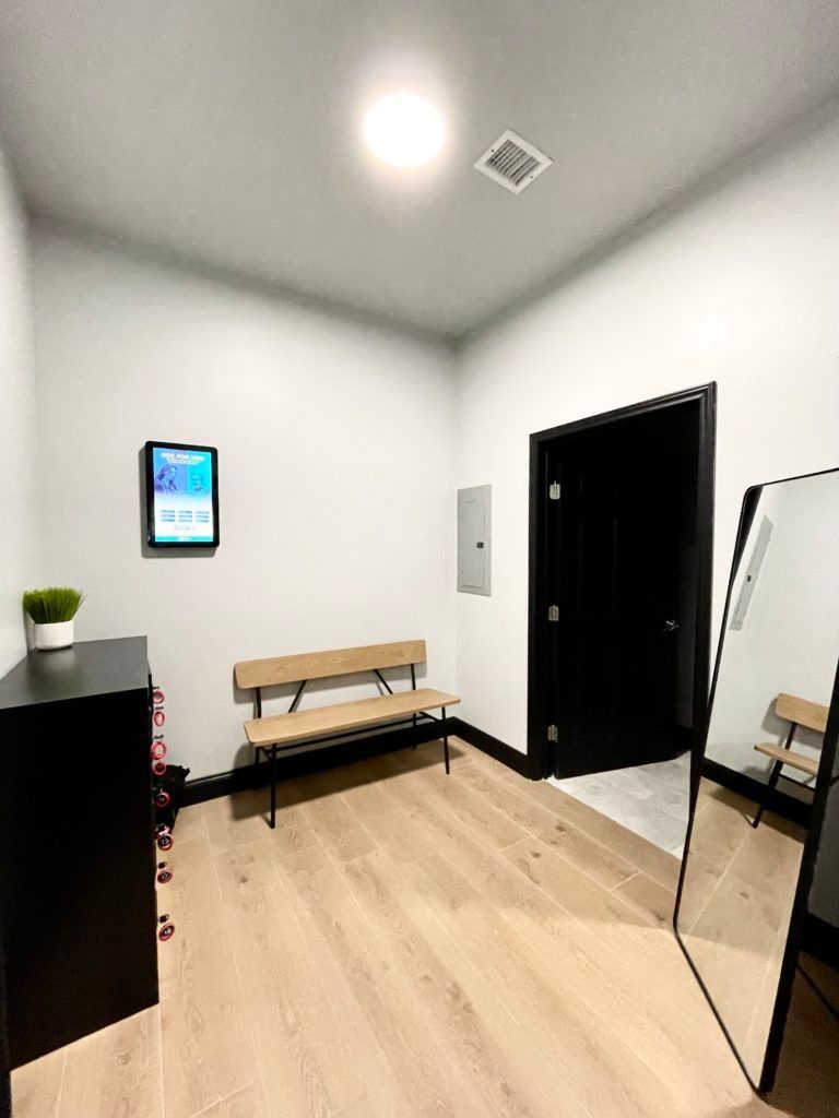 A room with a bench and a mirror in it.