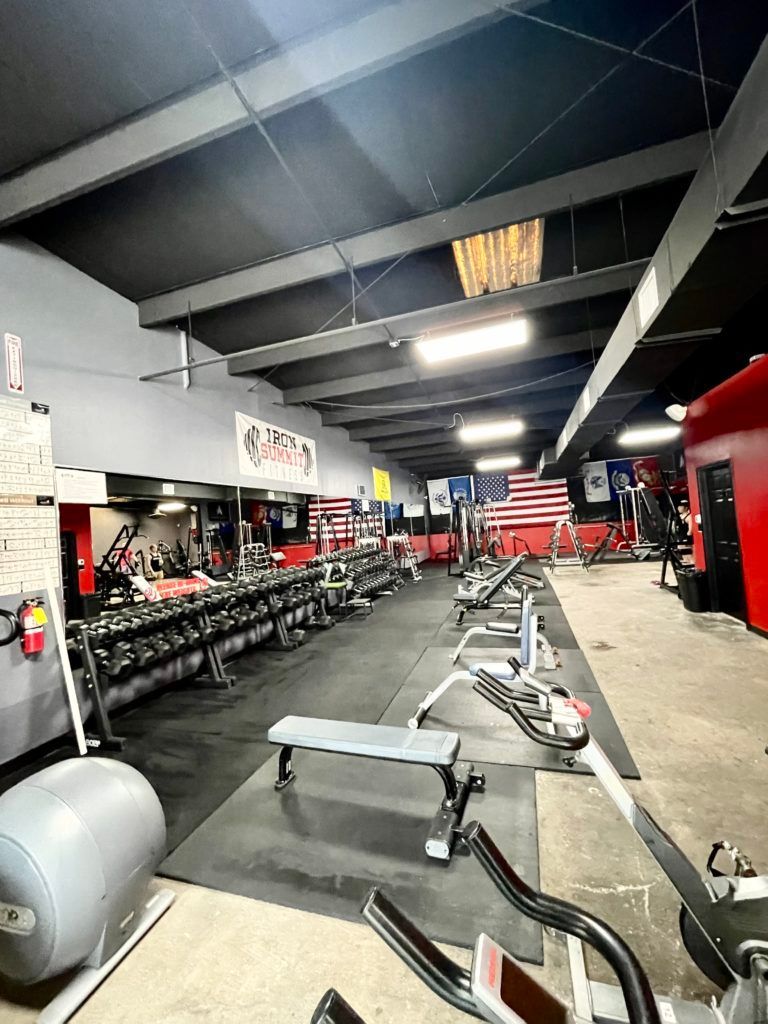 A large gym filled with lots of dumbbells and exercise equipment.