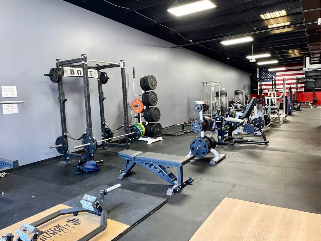 A large gym filled with lots of exercise equipment.