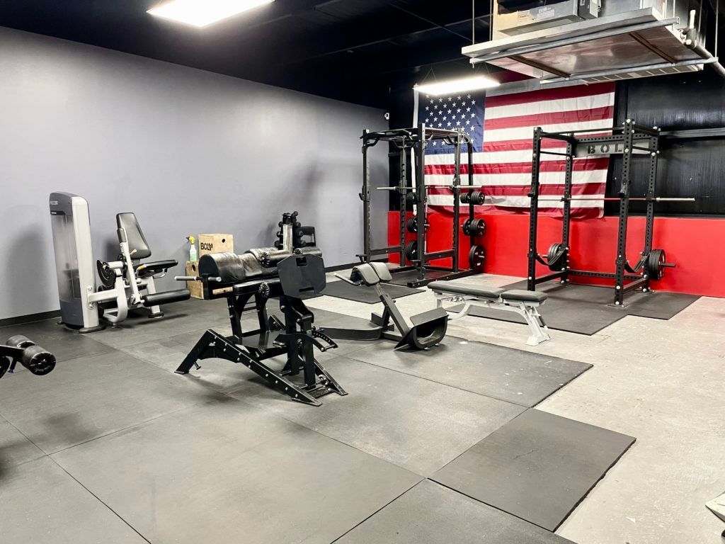 A large gym with a large american flag on the wall.
