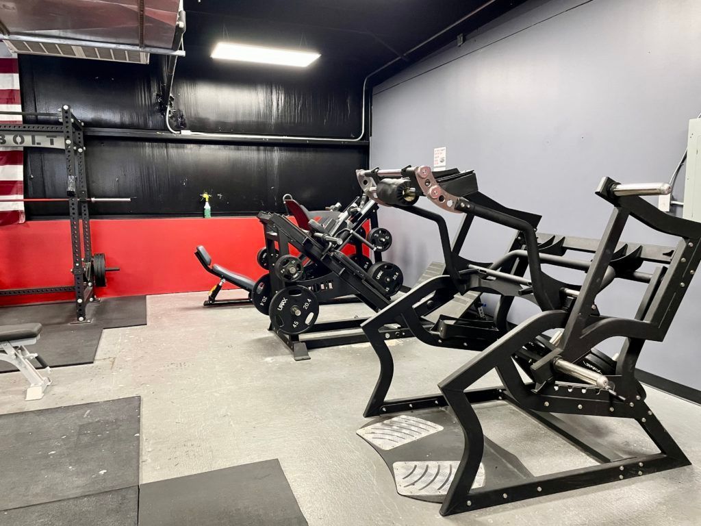 A gym with a lot of exercise equipment on the floor.