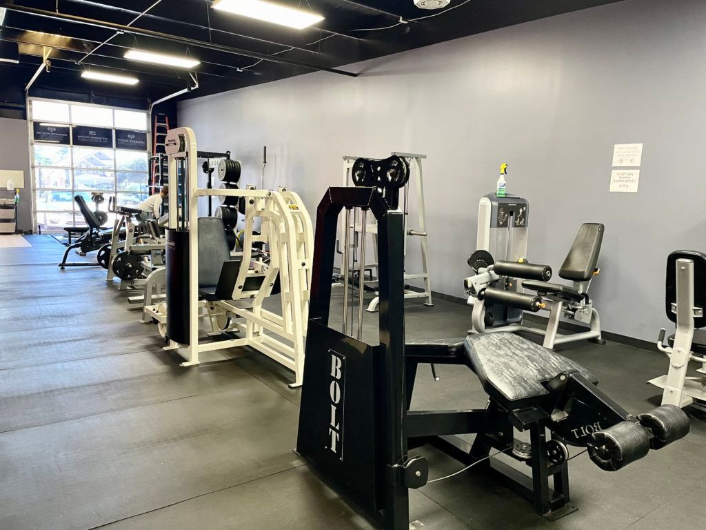 A large gym filled with lots of exercise equipment.