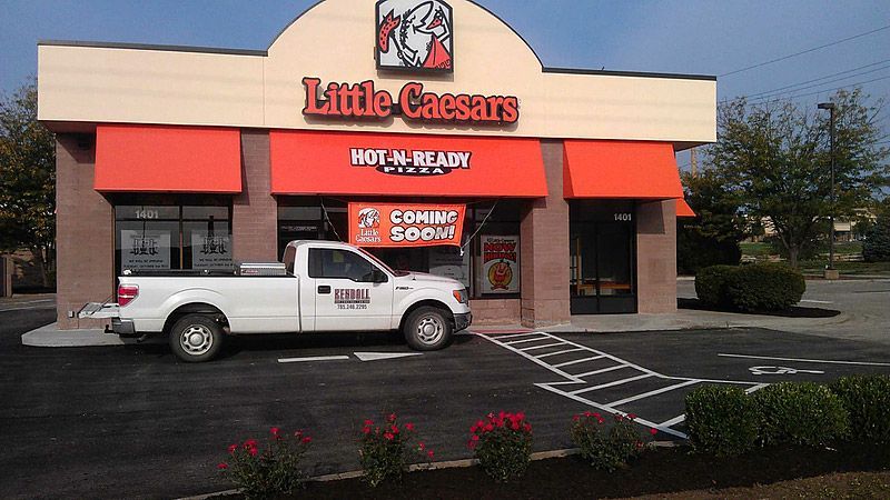 Little Caesars pizza restaurant with a white pickup truck parked outside; 