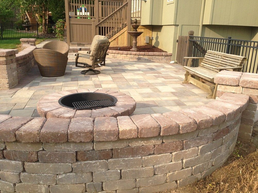 Brick patio with fire pit, seating, and wooden deck.