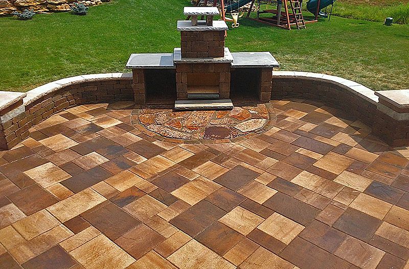 Outdoor patio with brick pavers, fireplace, and built-in counter.