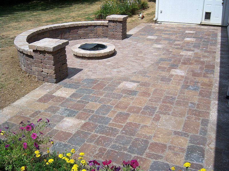 Brick patio with fire pit and colorful pavers.