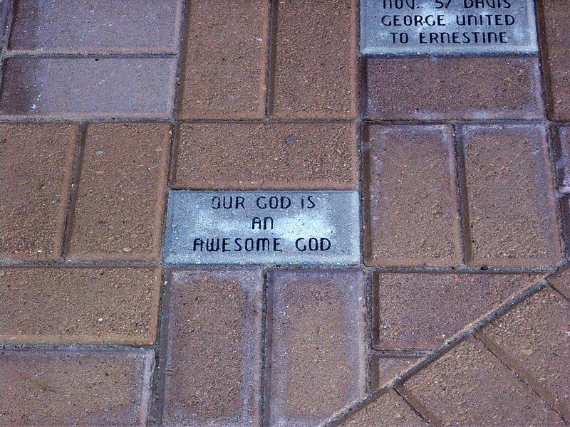 Brick pavement with a central gray brick stating 