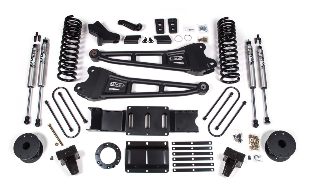 a bunch of suspension parts are sitting on top of each other on a white surface .