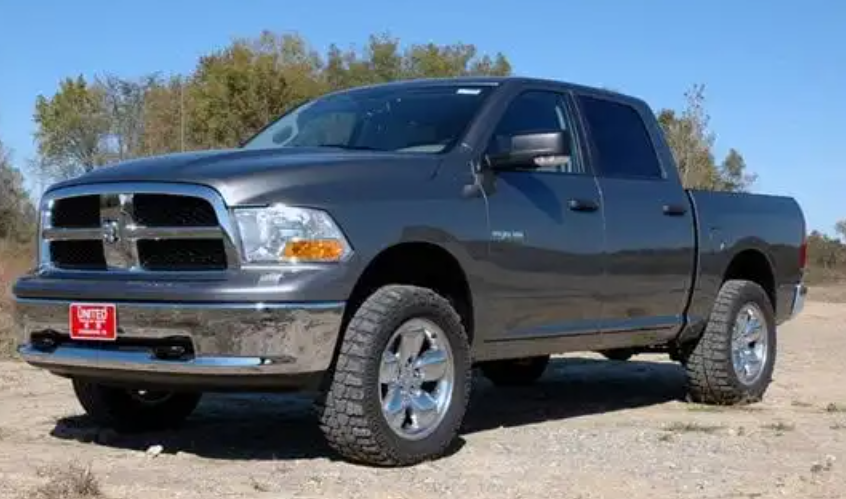 a gray dodge ram truck is parked on a dirt road .