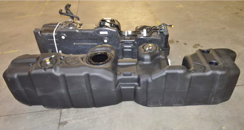 a black fuel tank is sitting on a concrete floor