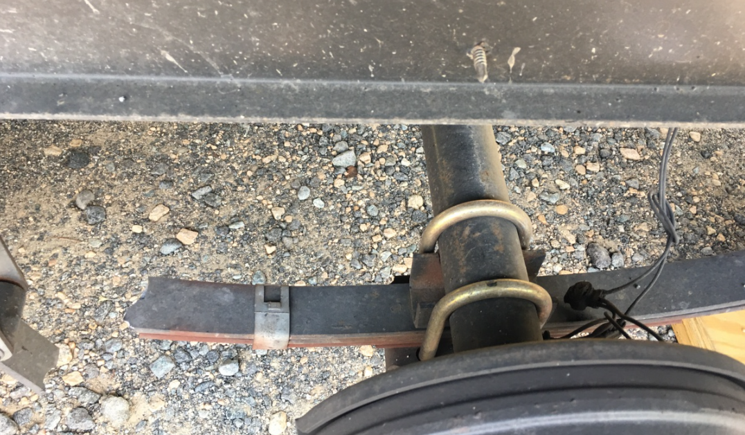 a close-up of a leaf spring on the back of a truck