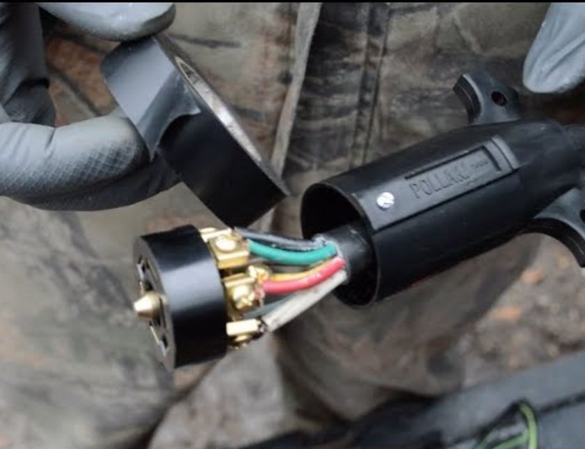 a close-up of a person holding a plug with wires