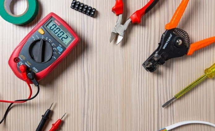 a bunch of electrical tools are on a wooden table
