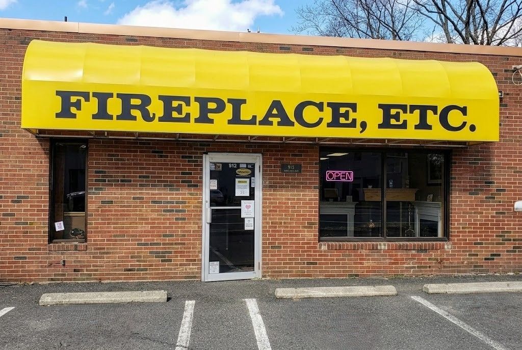Storefront with yellow awning reading FIREPLACE, ETC. on a brick building.