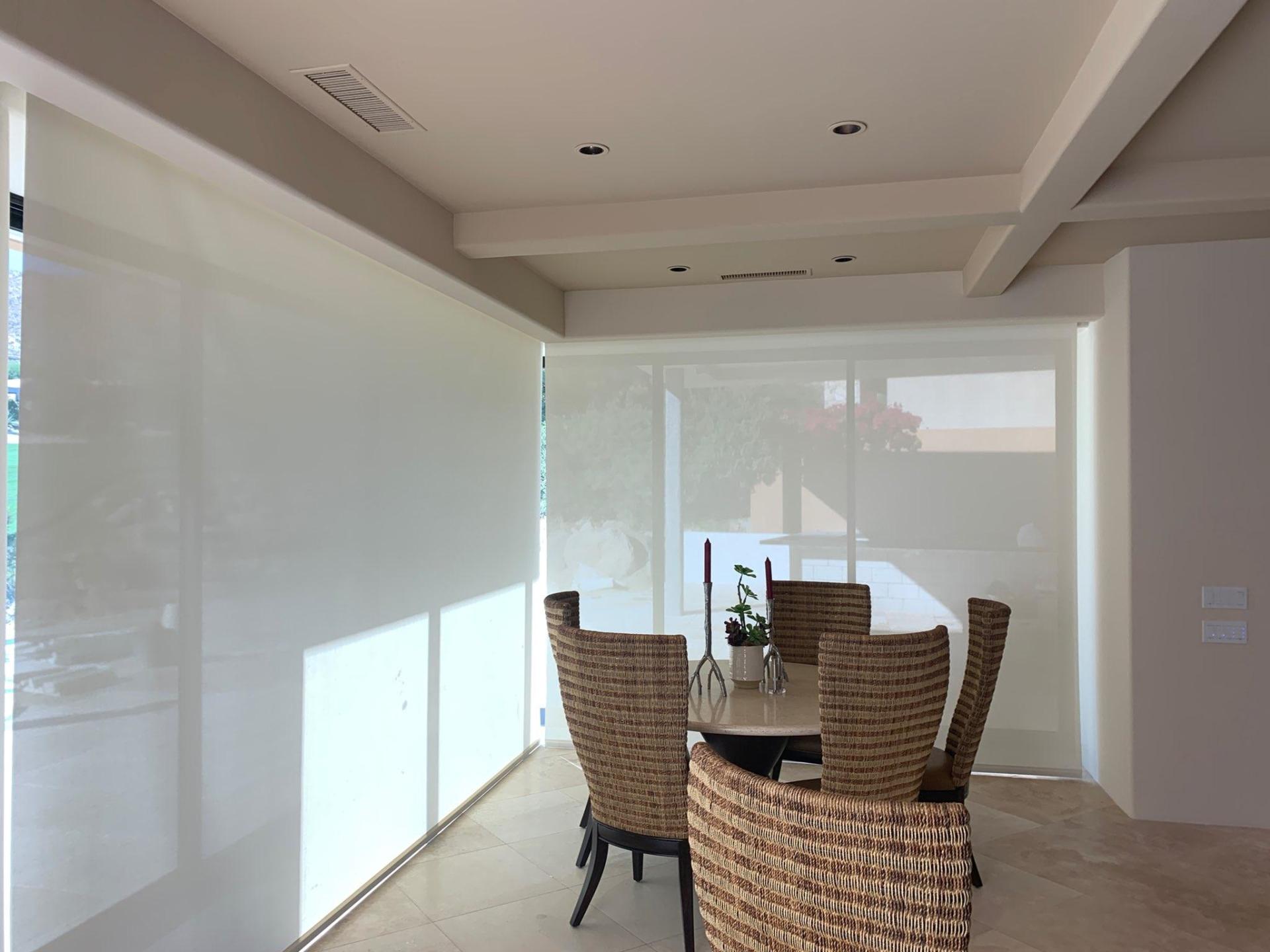 A dining room with wicker chairs and a table
