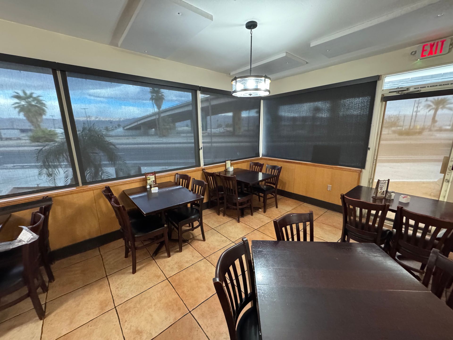 A restaurant with tables and chairs and a lot of windows.