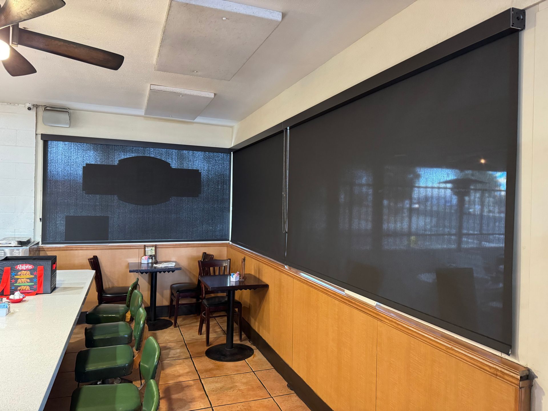 A restaurant with tables and chairs and a ceiling fan.