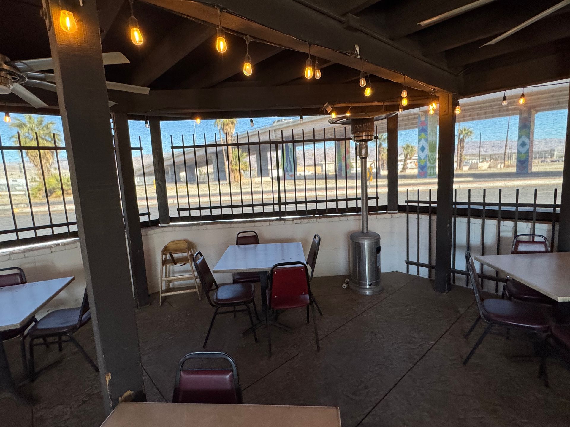 A patio with tables and chairs and a heater.