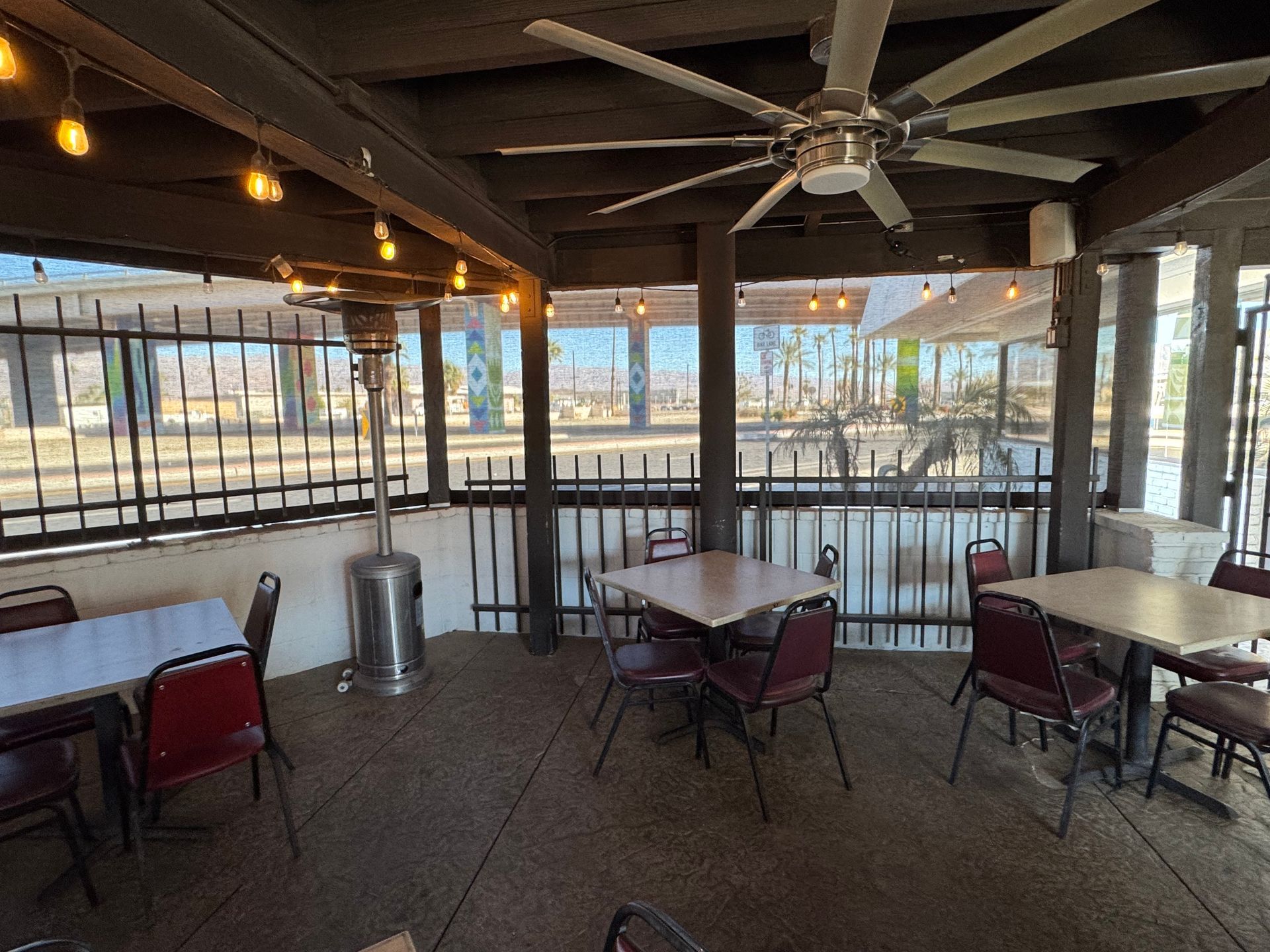 A restaurant with tables and chairs and a ceiling fan.