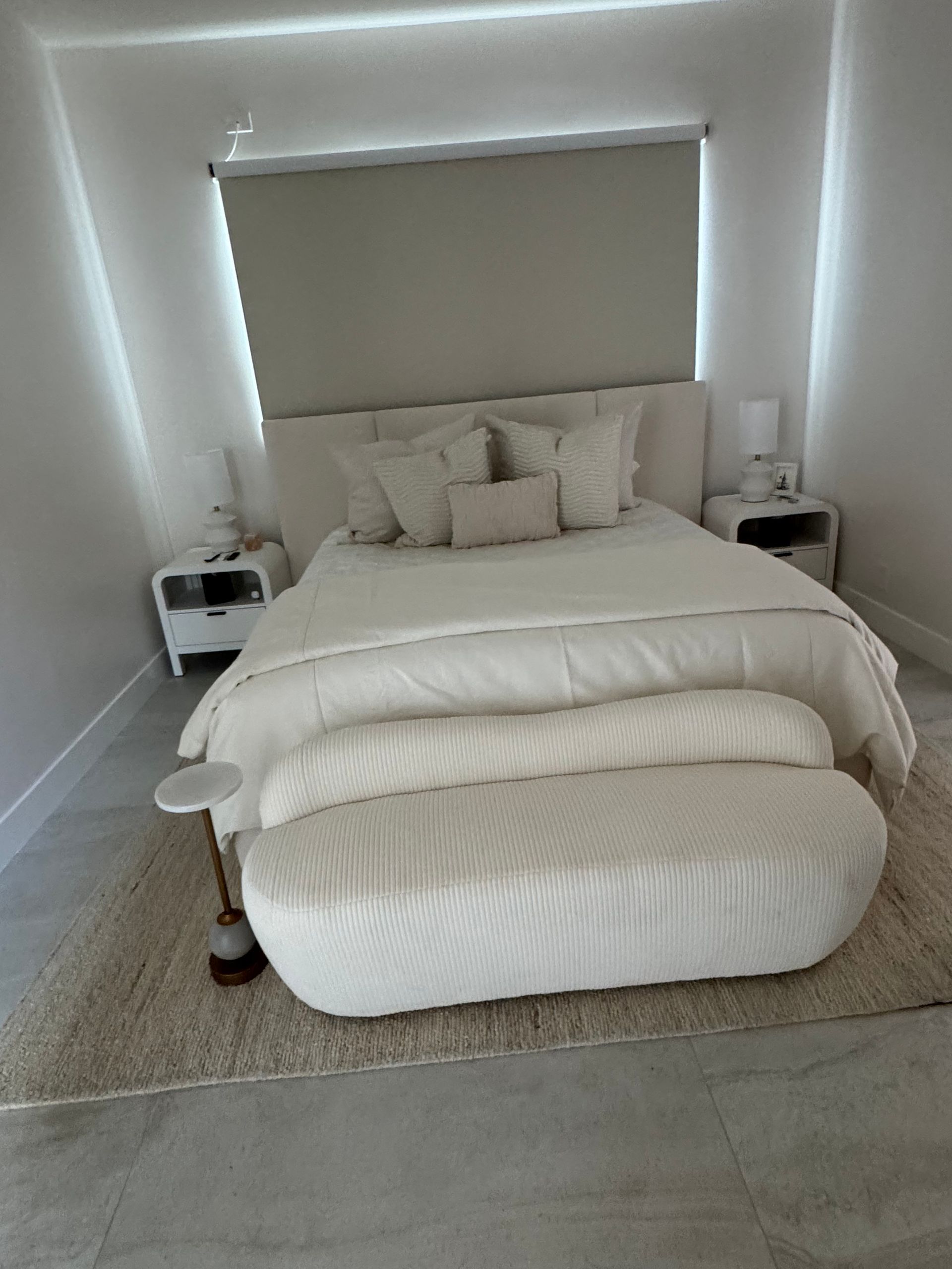 A bedroom with a bed , nightstands , and a bench.