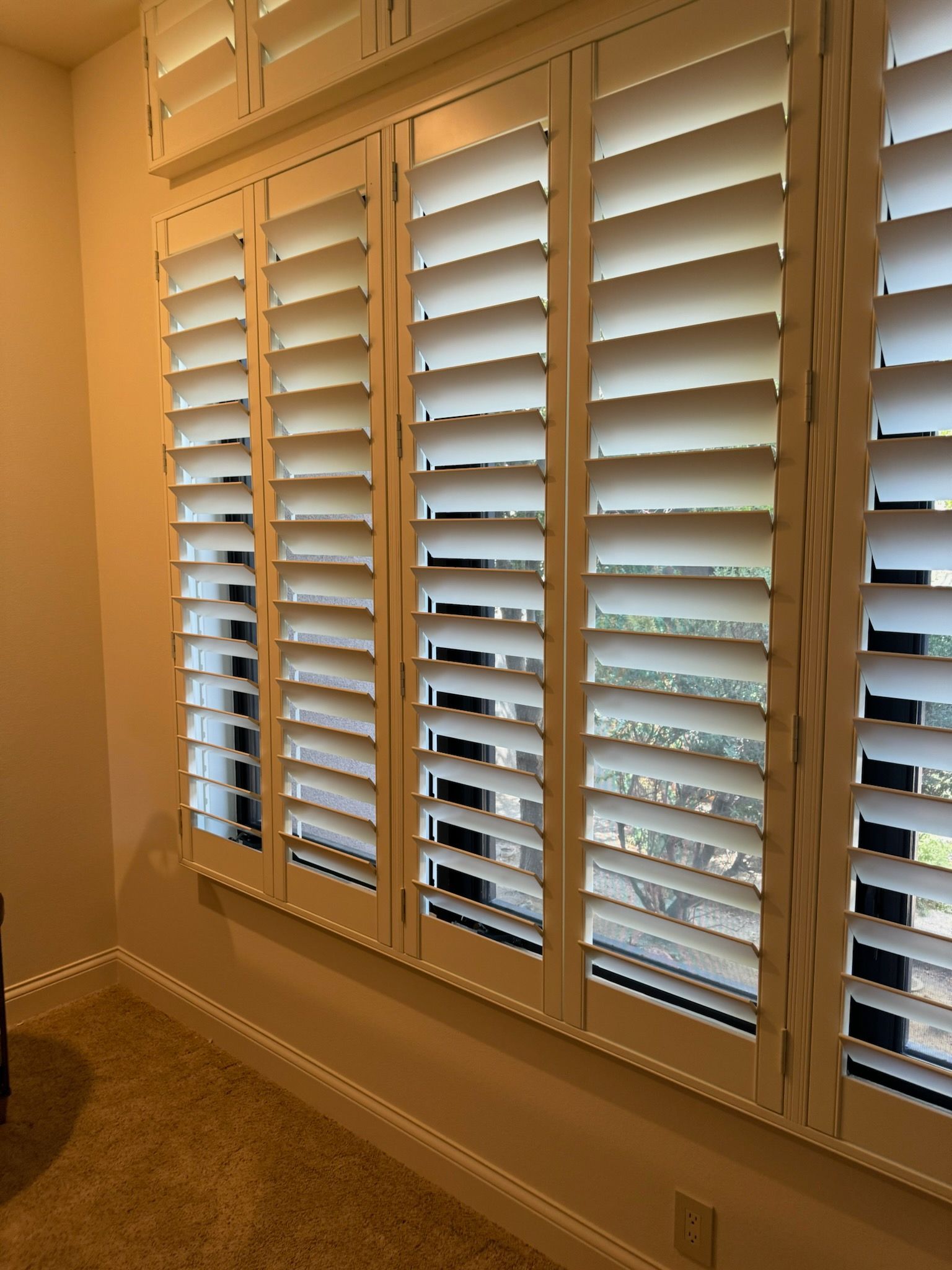 A room with a lot of shutters on the windows