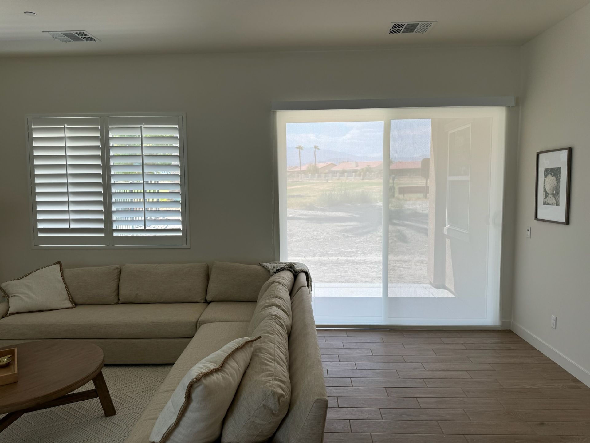 A living room with a couch, coffee table, and sliding glass doors.