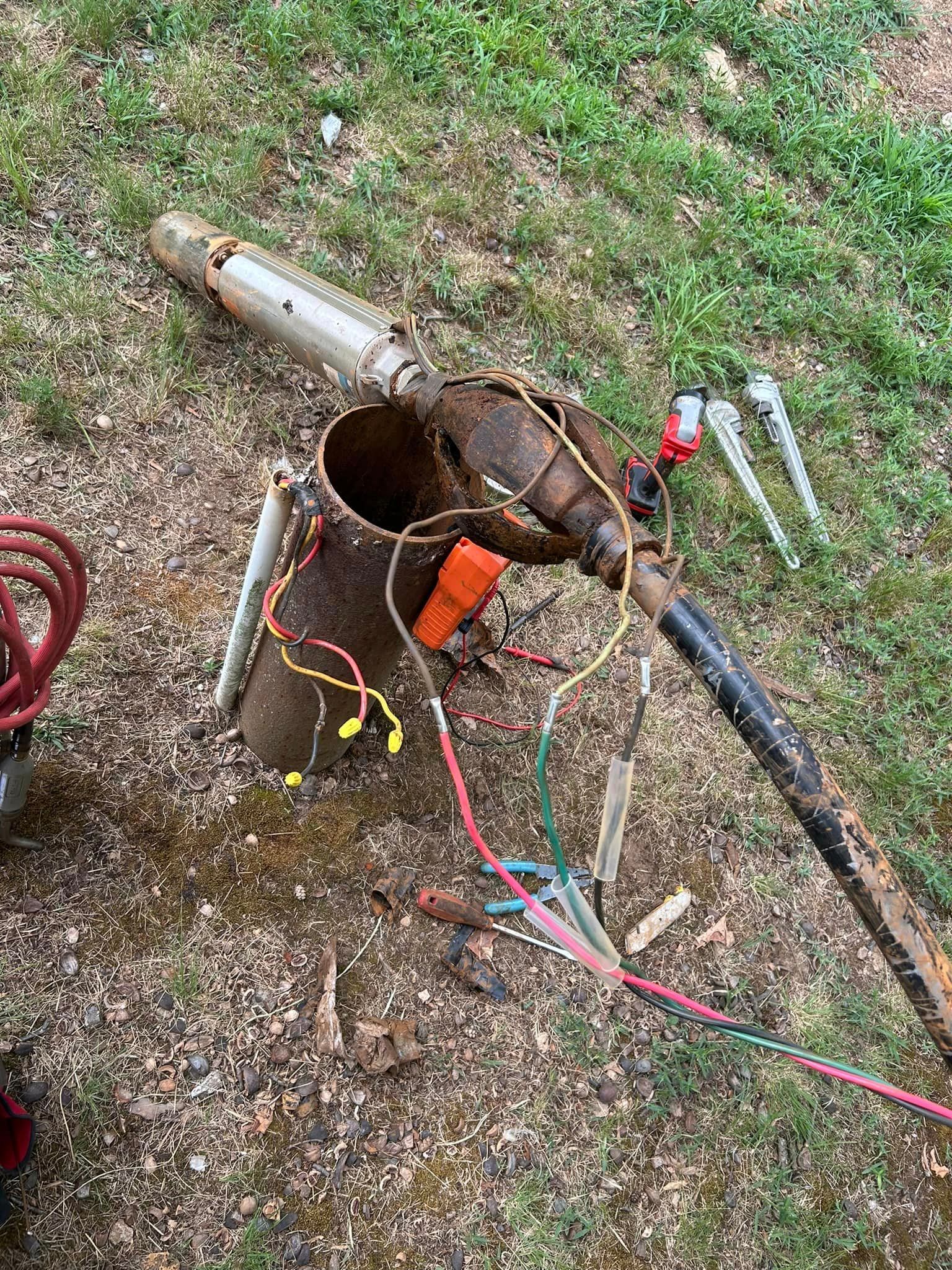 A bunch of wires are laying on the ground next to a bucket.