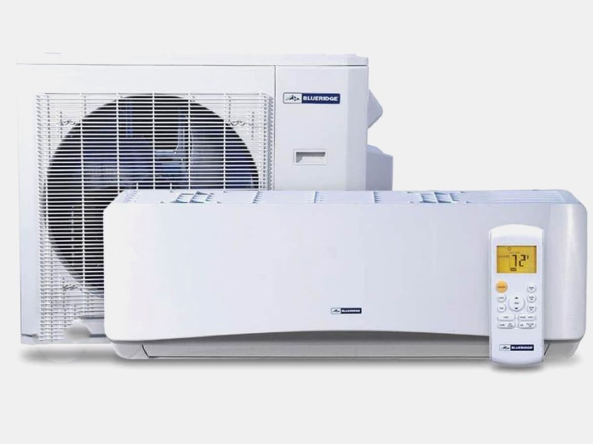 A white air conditioner with a remote control next to it