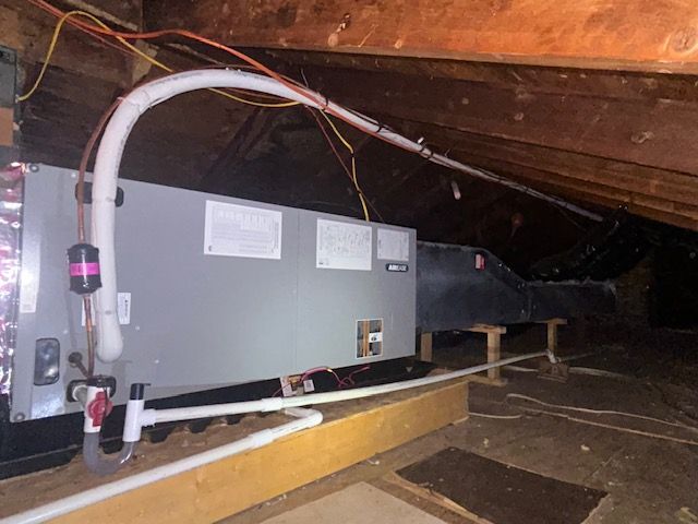 An air conditioner is installed in the attic of a house.