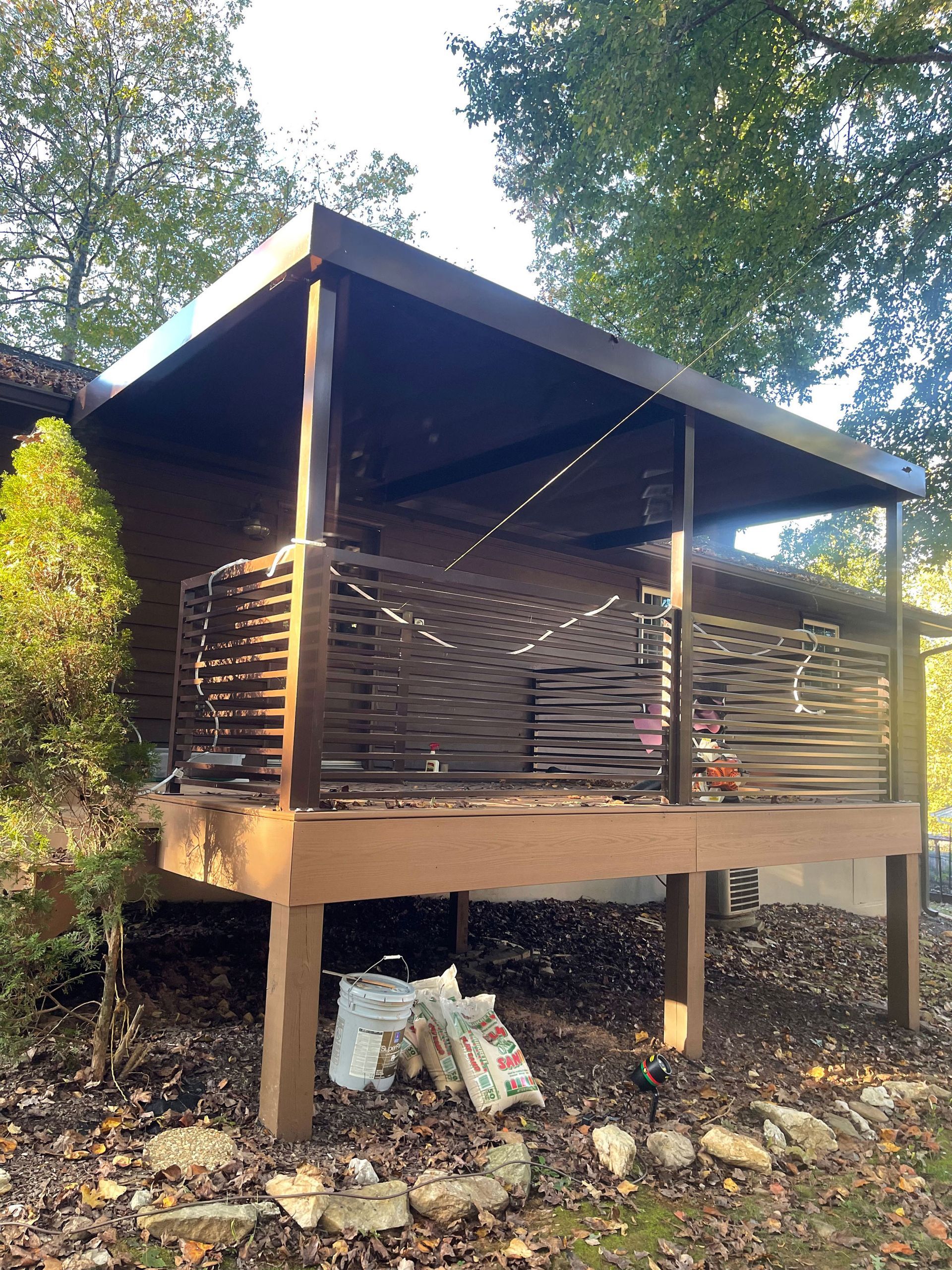 A small house with a wooden deck and a covered porch.