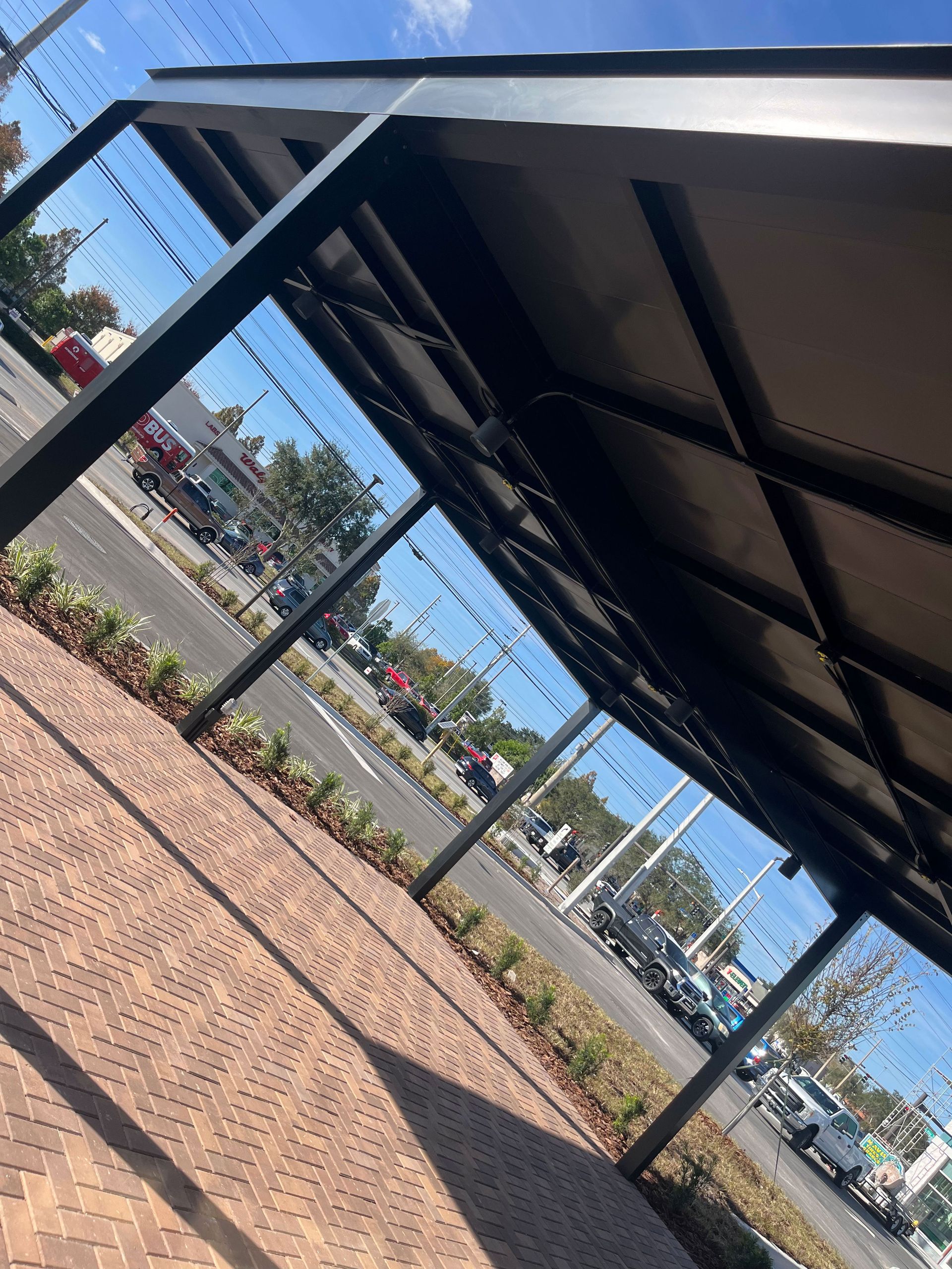 A canopy over a parking lot with cars parked underneath it