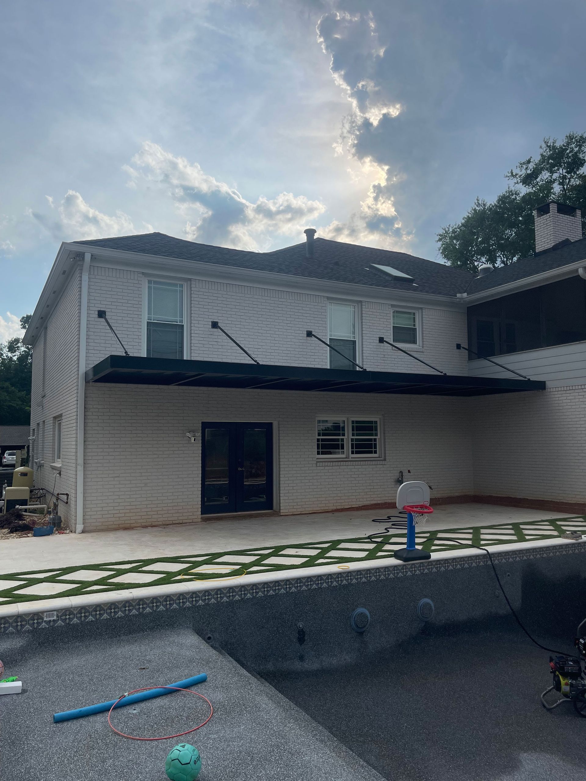 A large white house with a swimming pool in front of it.