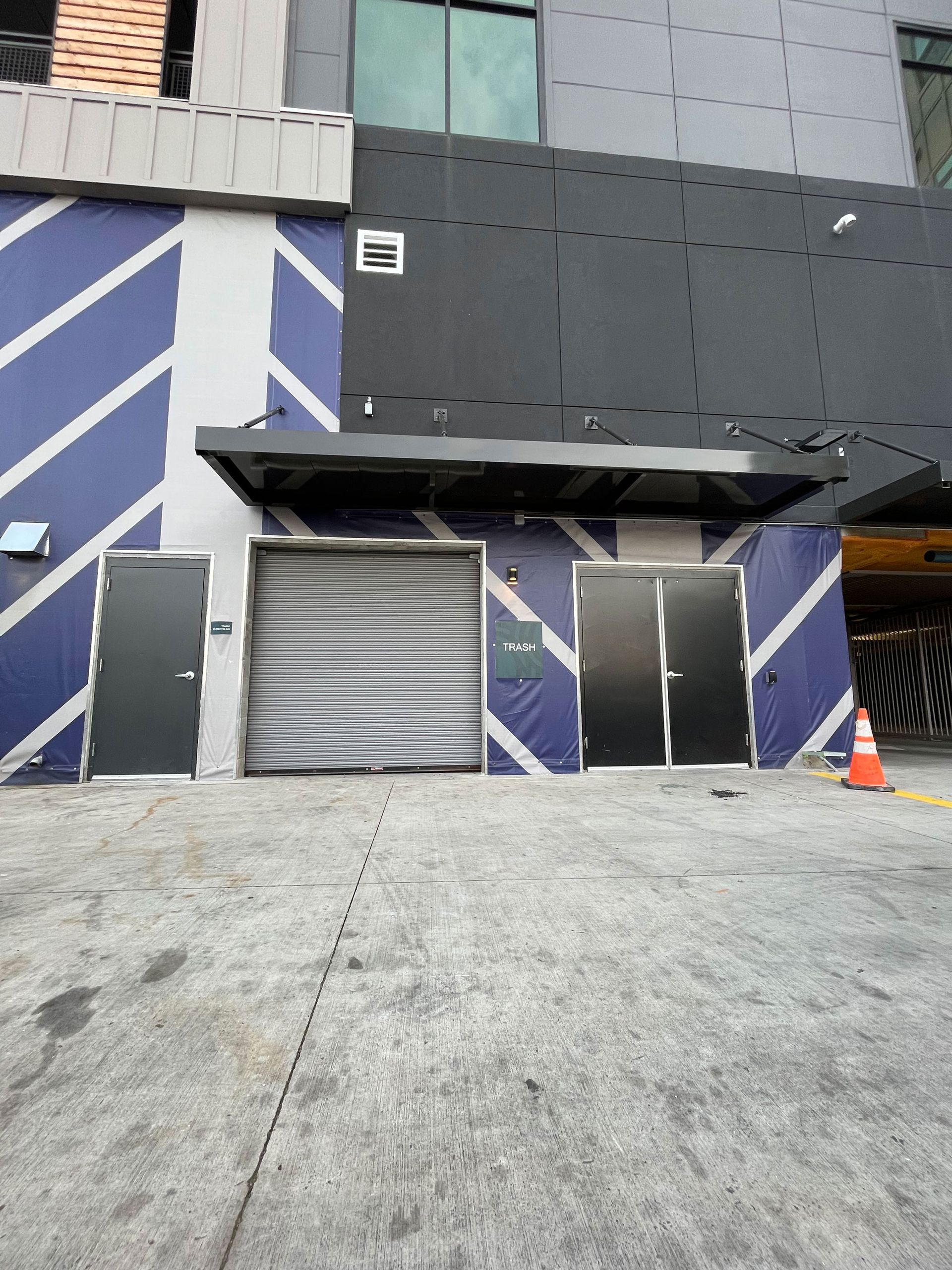 A building with a lot of doors and a parking lot in front of it