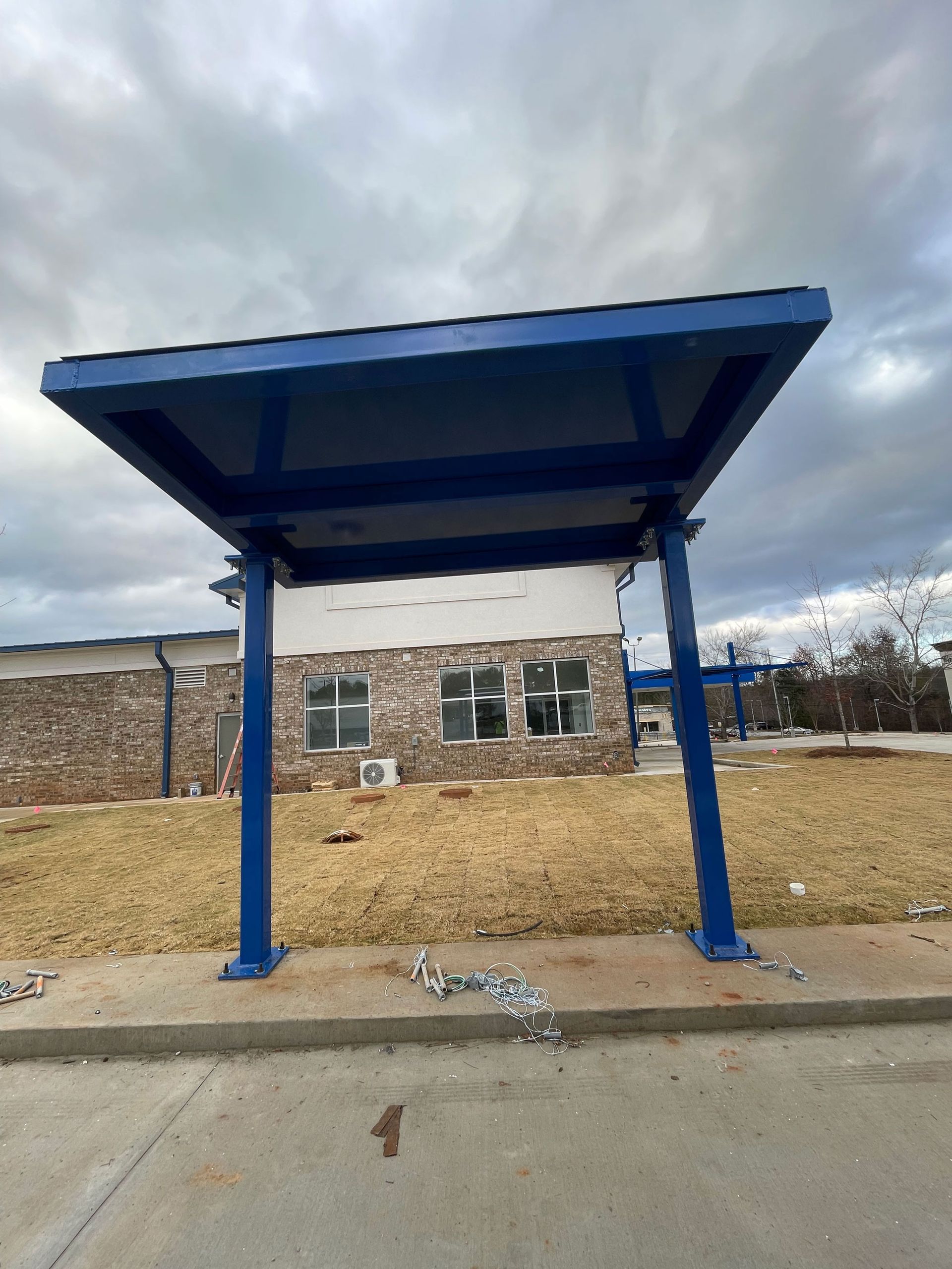 A blue shelter is in front of a building