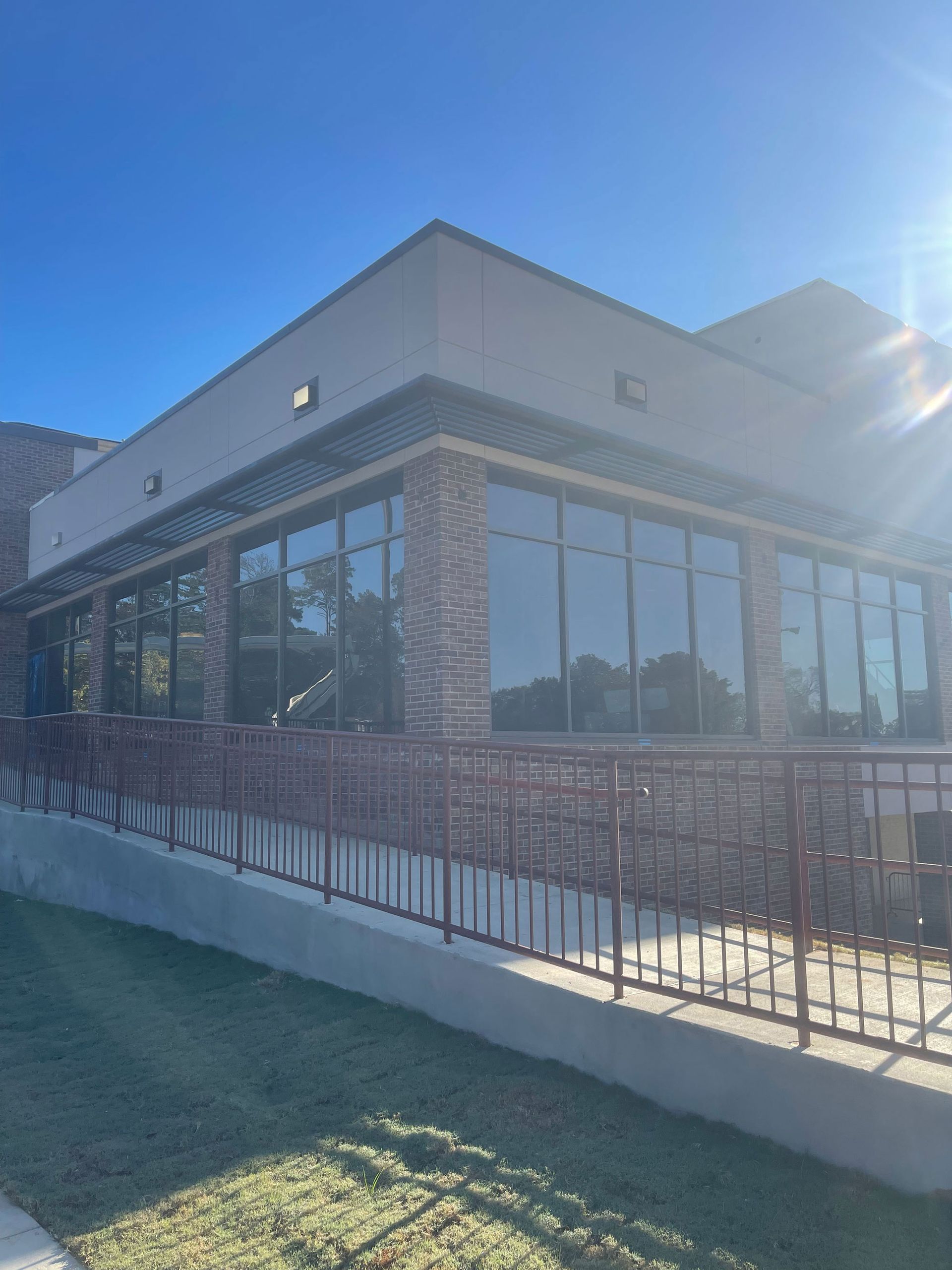 A large building with a lot of windows and a fence around it.