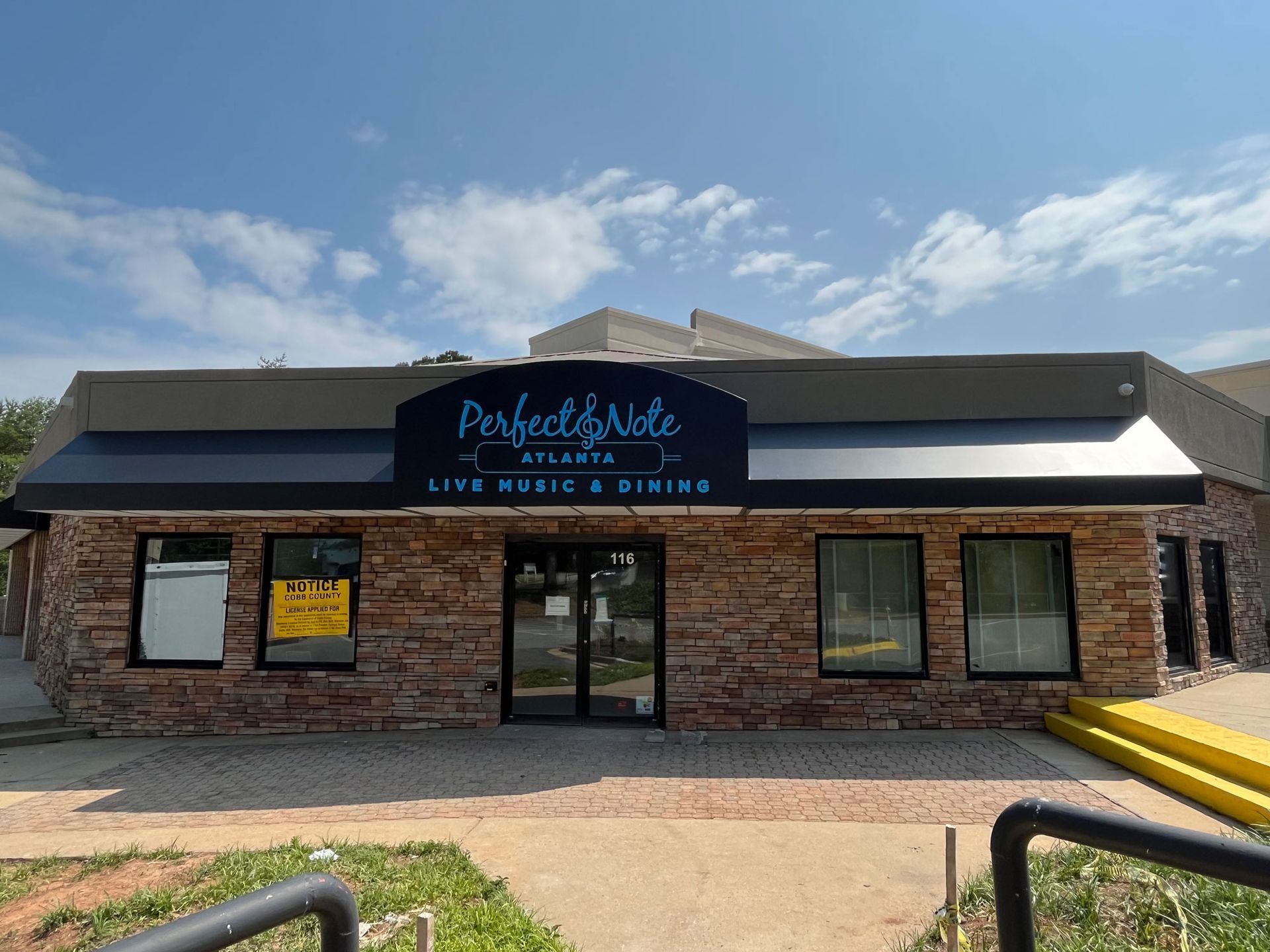 A brick building with a sign that says perfect note
