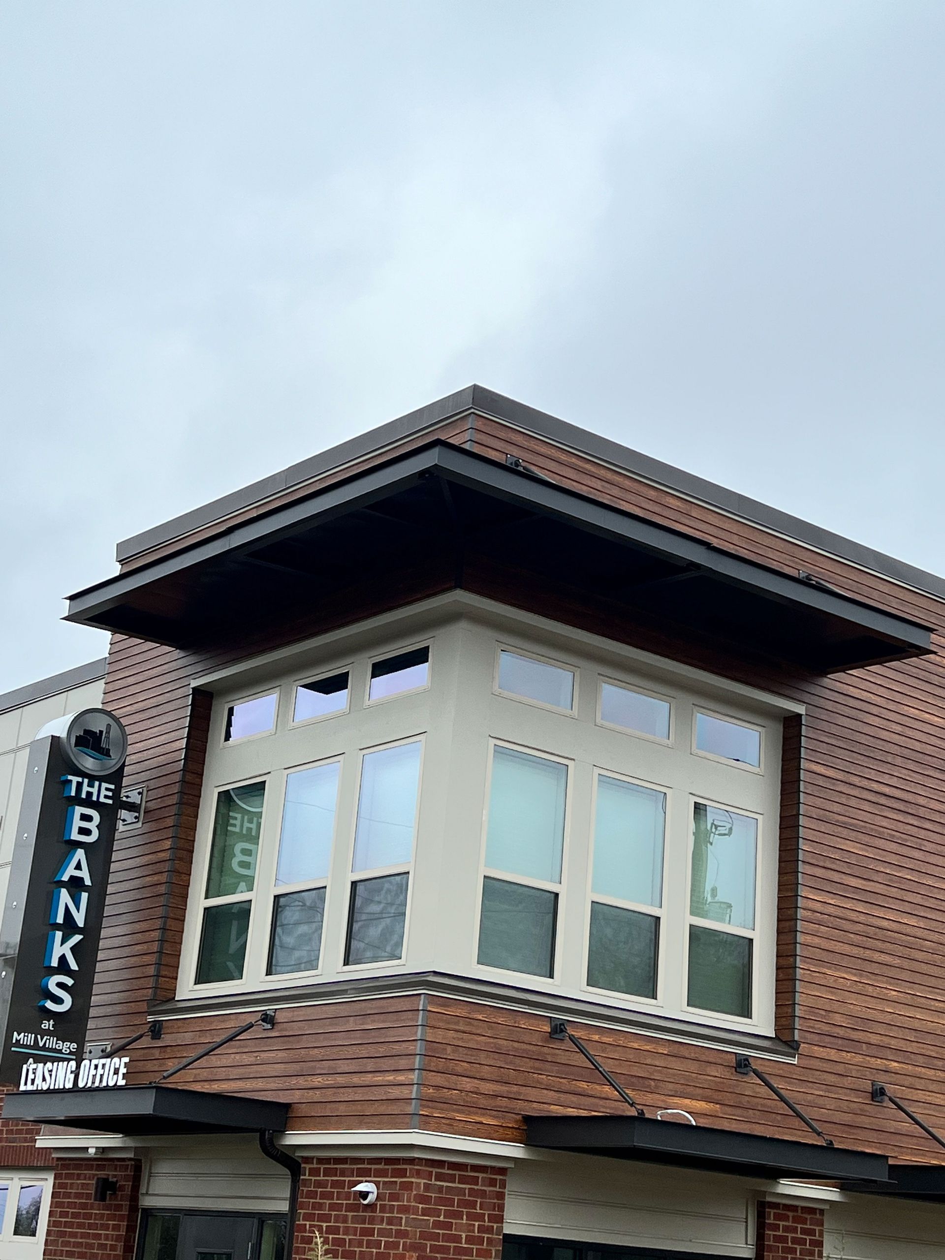 An entrance to a restaurant with tables and chairs under a canopy