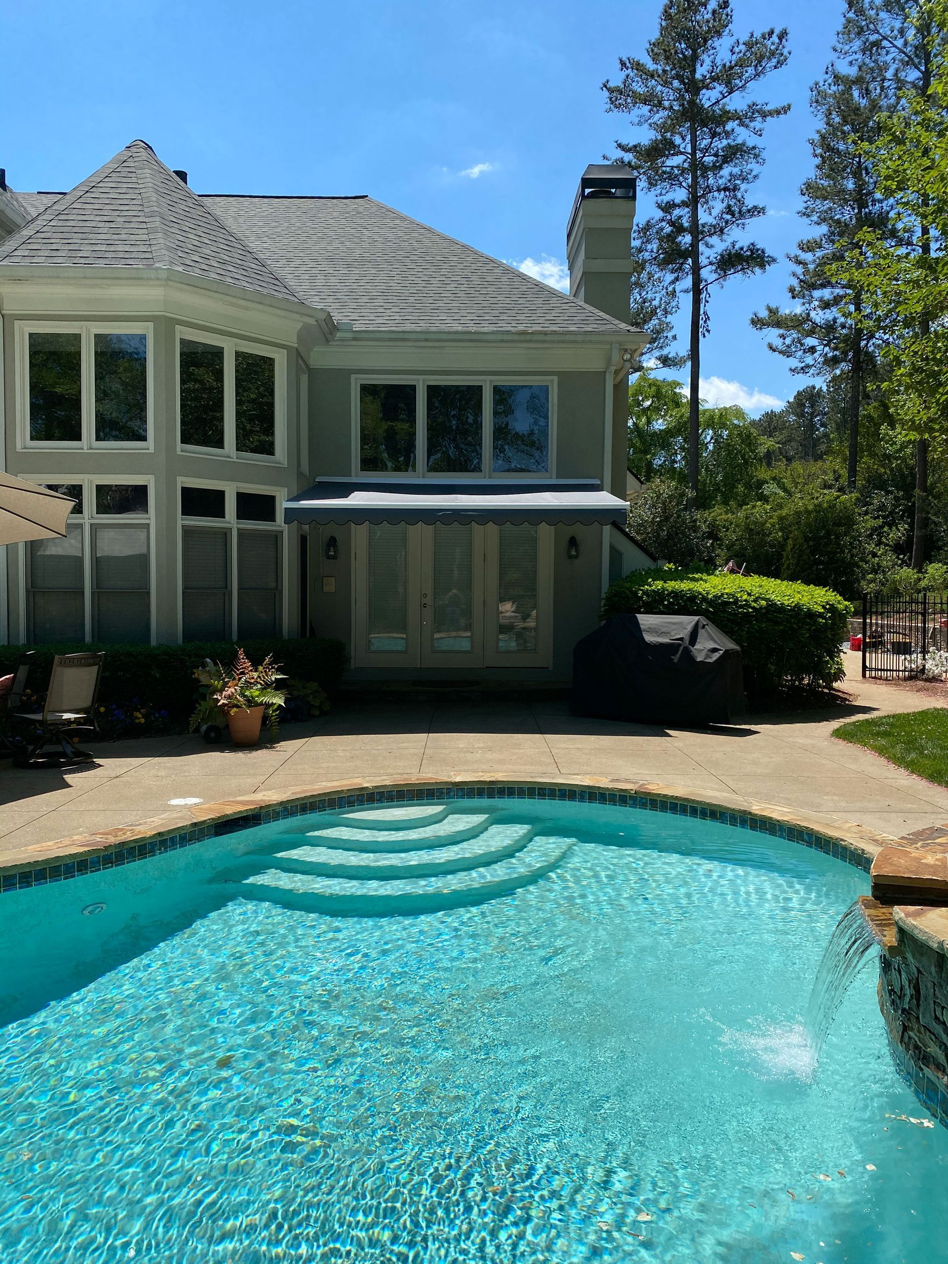 A large house with a swimming pool in front of it
