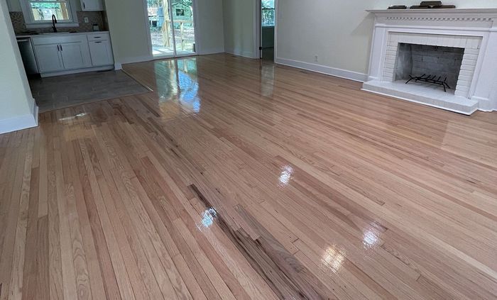 A living room with hardwood floors and a fireplace.