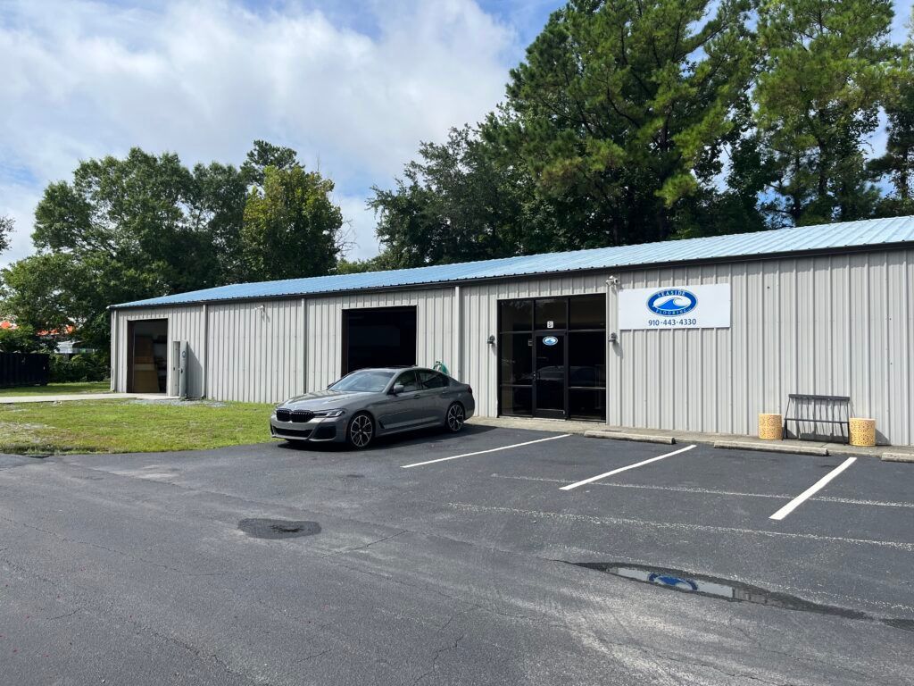 A car is parked in front of a building in a parking lot.