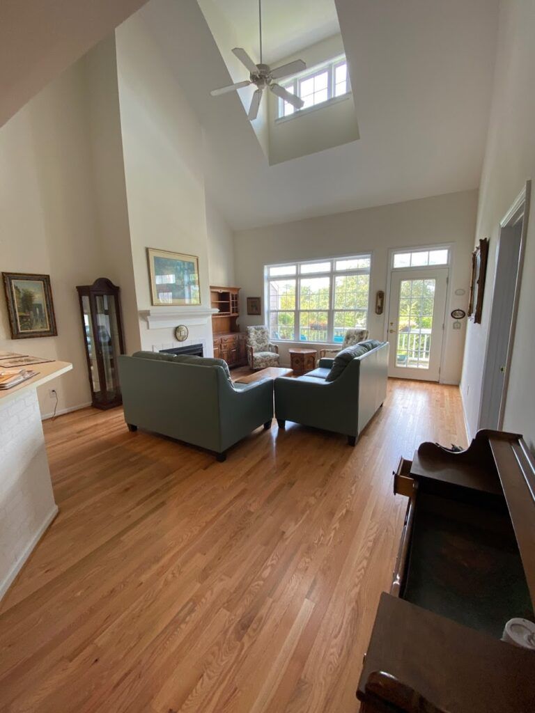A living room with hardwood floors and a ceiling fan.
