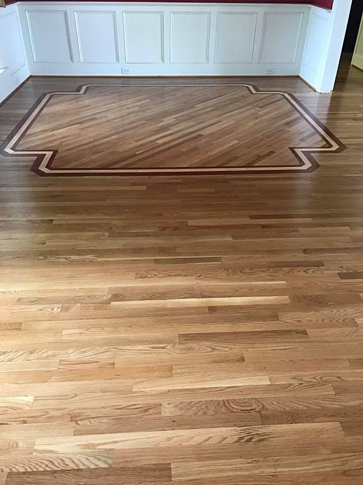 A wooden floor with a rug on it in a living room.
