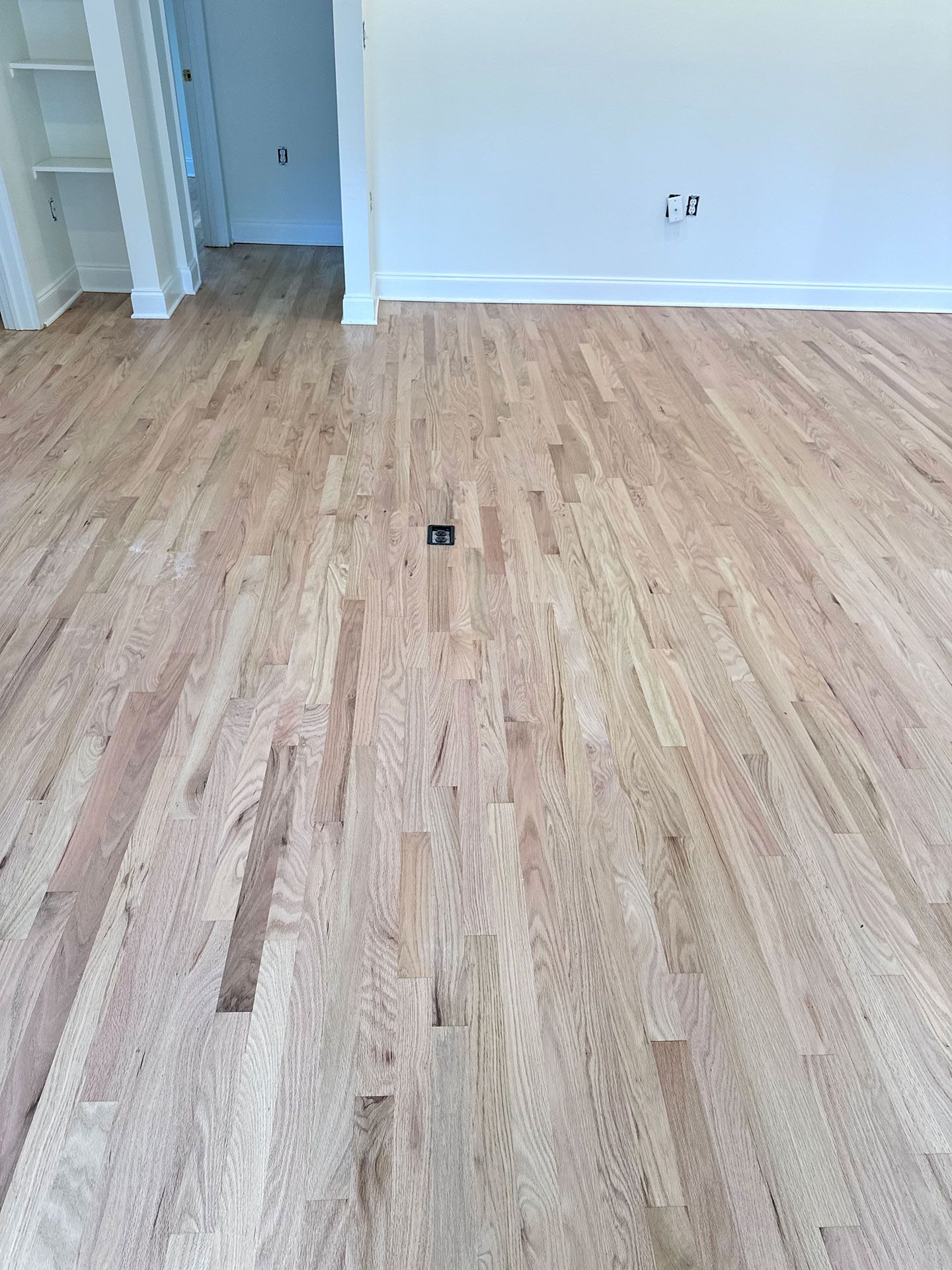 A living room with hardwood floors and white walls.