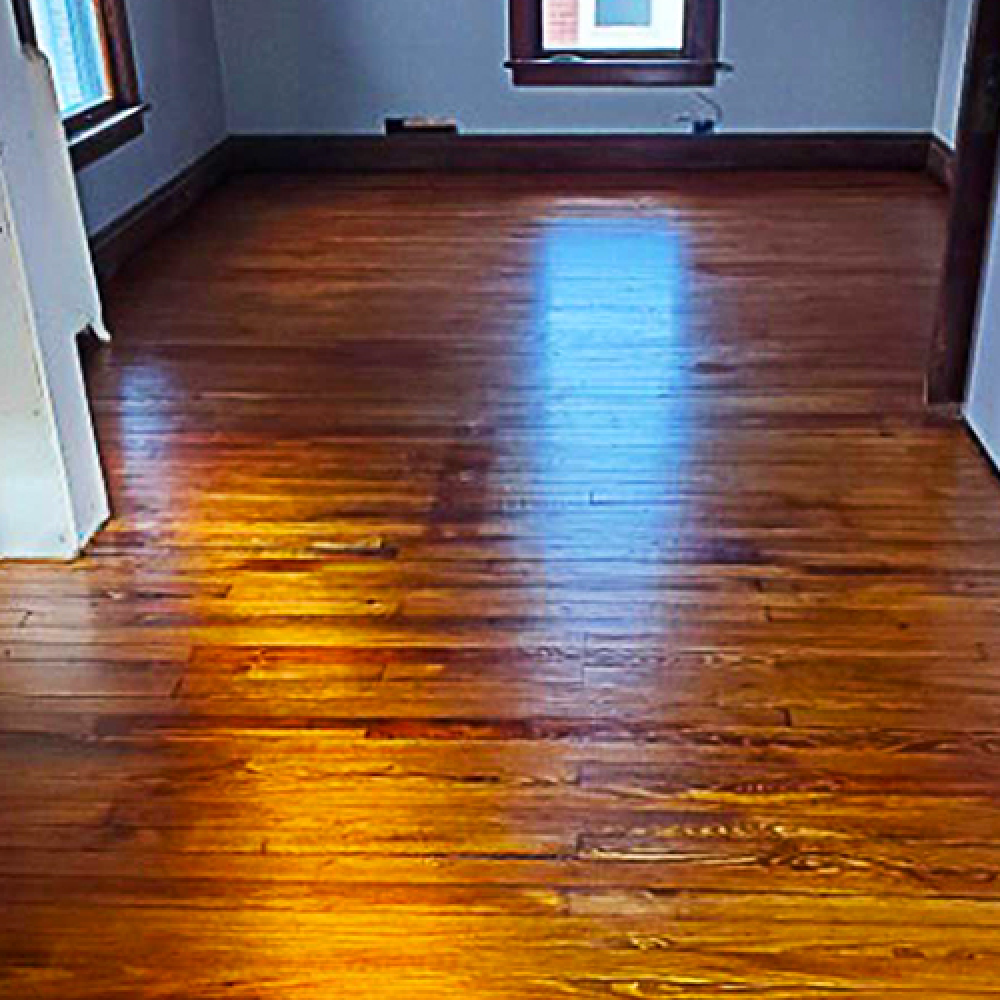 A living room with hardwood floors and a window.