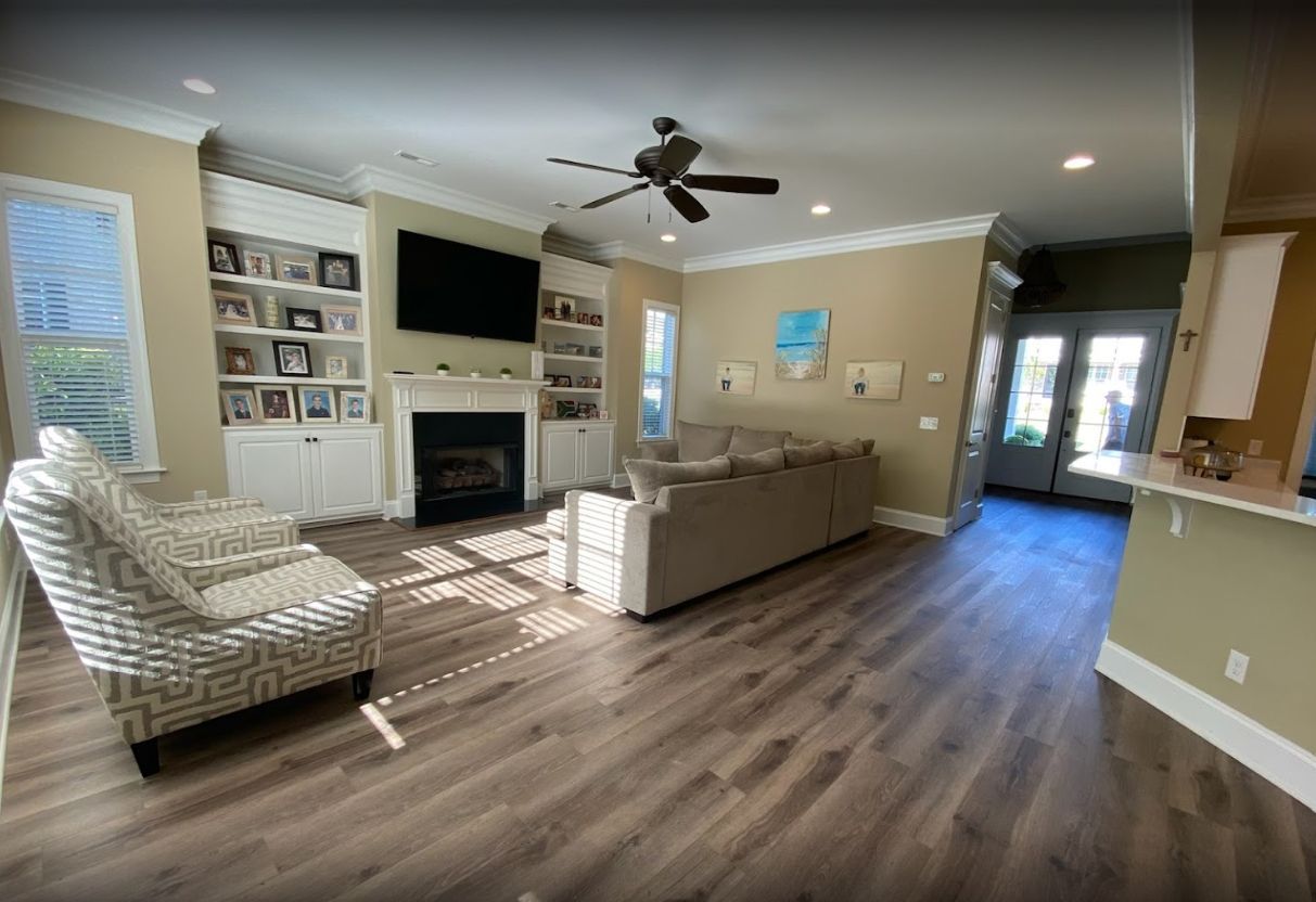 A living room with a couch , chair , fireplace and television.