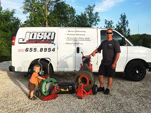 Man and child standing beside service van
